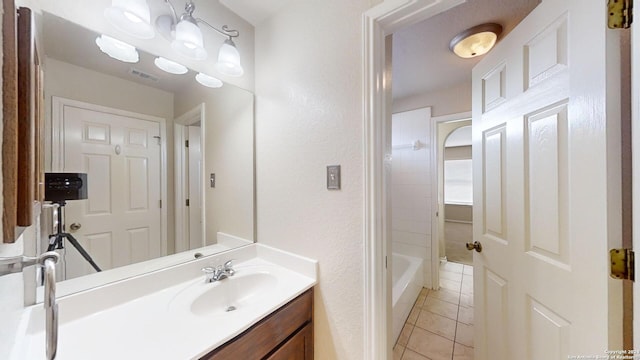 bathroom with bathing tub / shower combination, vanity, and tile patterned flooring