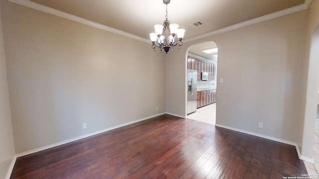 empty room with ornamental molding, hardwood / wood-style flooring, and an inviting chandelier