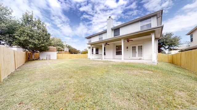 back of property with ceiling fan, a patio, and a yard