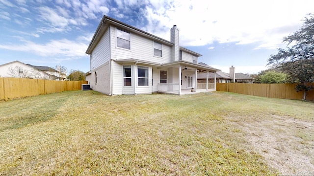 back of house with central AC and a yard