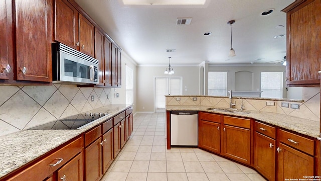 kitchen featuring sink, crown molding, backsplash, appliances with stainless steel finishes, and decorative light fixtures