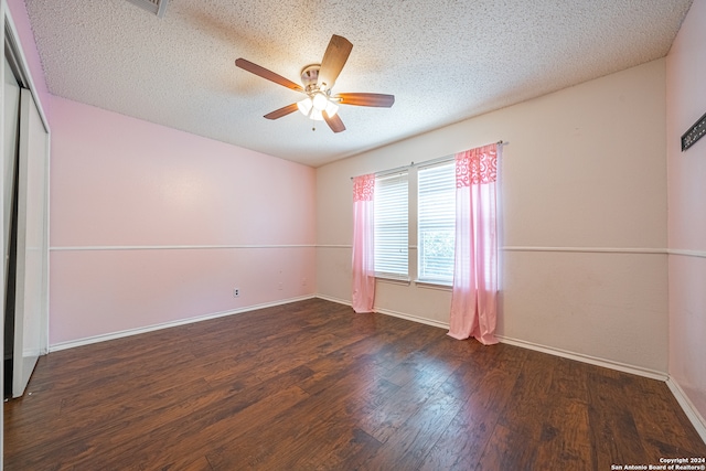 unfurnished room featuring a textured ceiling, dark hardwood / wood-style flooring, and ceiling fan