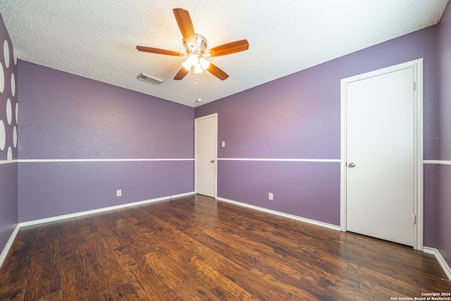 unfurnished room with a textured ceiling, dark hardwood / wood-style floors, and ceiling fan