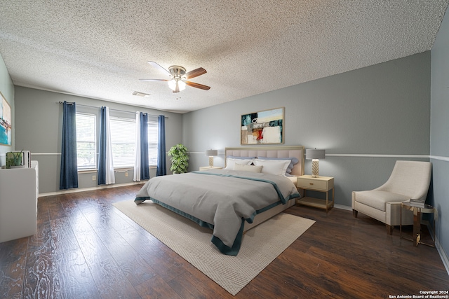 bedroom featuring ceiling fan, dark hardwood / wood-style floors, and a textured ceiling