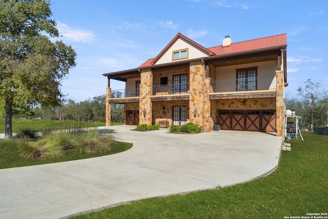 view of front of home featuring a garage, a balcony, and a front lawn