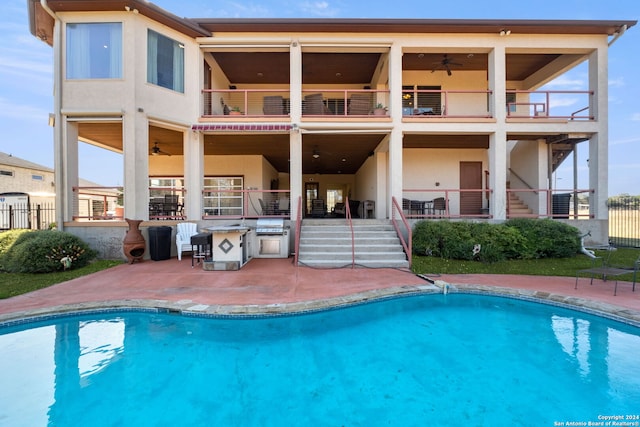 rear view of property with a patio, a balcony, and ceiling fan