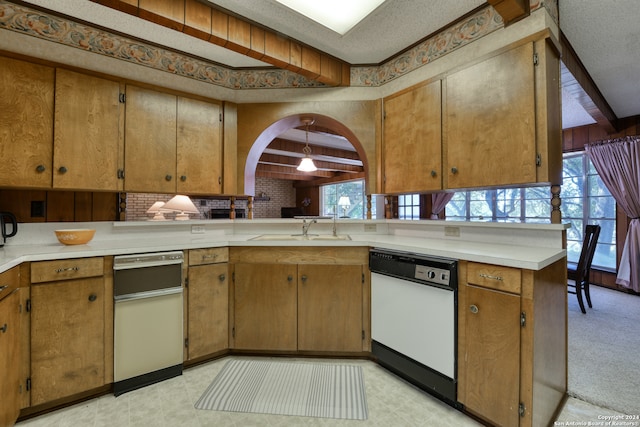 kitchen with beamed ceiling, kitchen peninsula, a textured ceiling, and white dishwasher