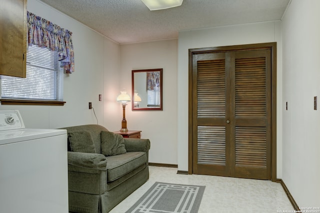 sitting room featuring light carpet, a textured ceiling, and washer / dryer