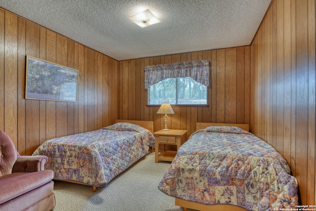 bedroom featuring a textured ceiling, carpet, and wooden walls