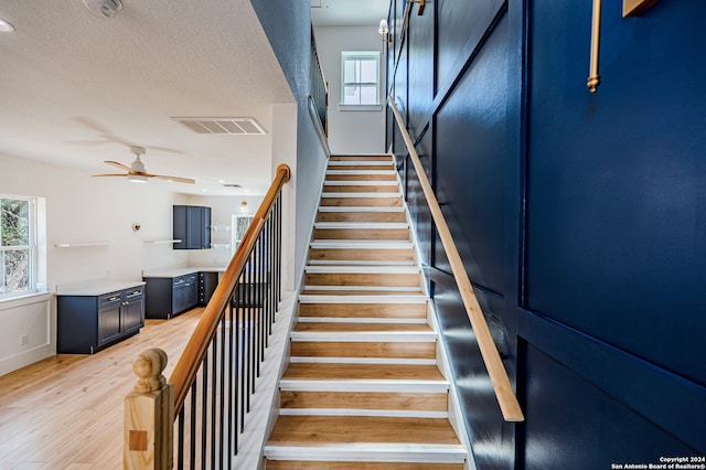 stairs featuring hardwood / wood-style floors and a textured ceiling