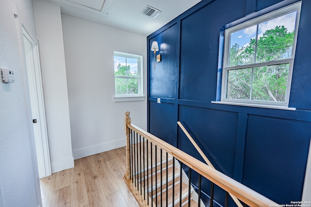 hall with a wealth of natural light and light hardwood / wood-style flooring