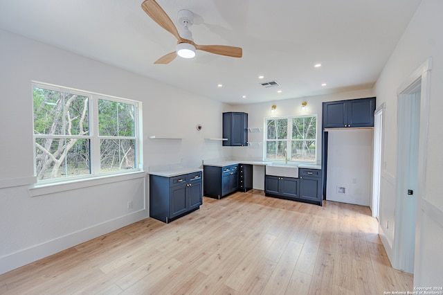 kitchen featuring blue cabinetry, light wood-type flooring, and ceiling fan