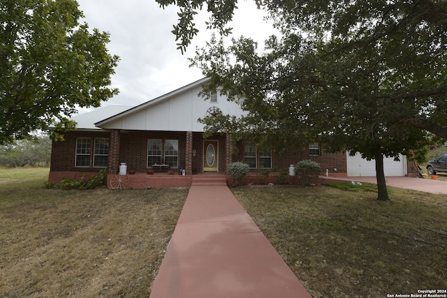 single story home with a front lawn, a garage, and covered porch