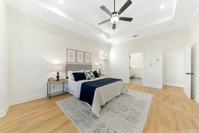 bedroom featuring a tray ceiling, light hardwood / wood-style flooring, ceiling fan, and ornamental molding