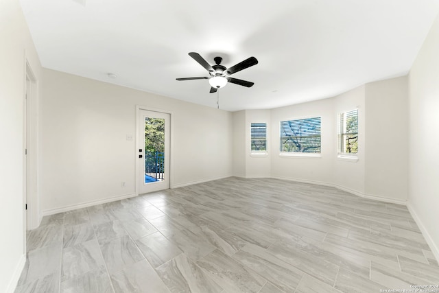 empty room featuring ceiling fan and a healthy amount of sunlight