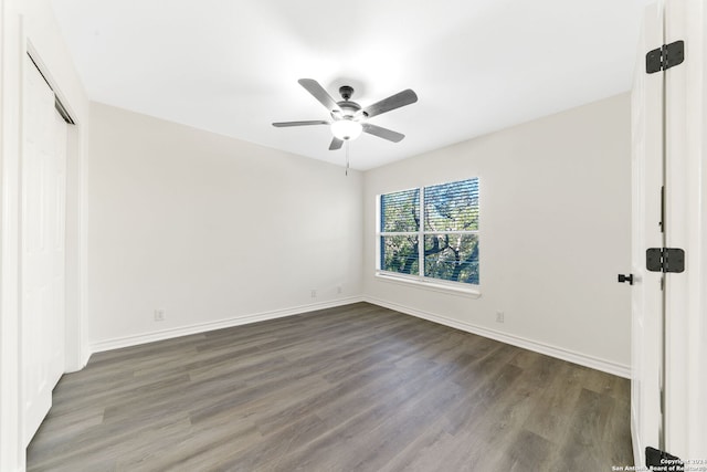 unfurnished bedroom with ceiling fan and dark wood-type flooring