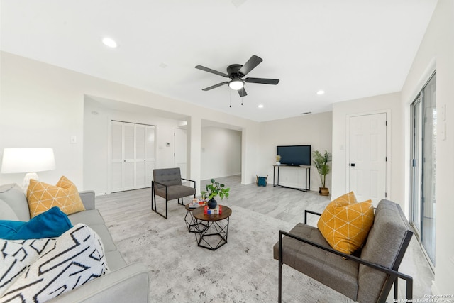 living room with ceiling fan and light wood-type flooring