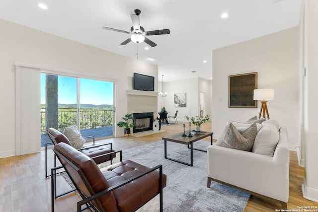 living room with light hardwood / wood-style flooring and ceiling fan