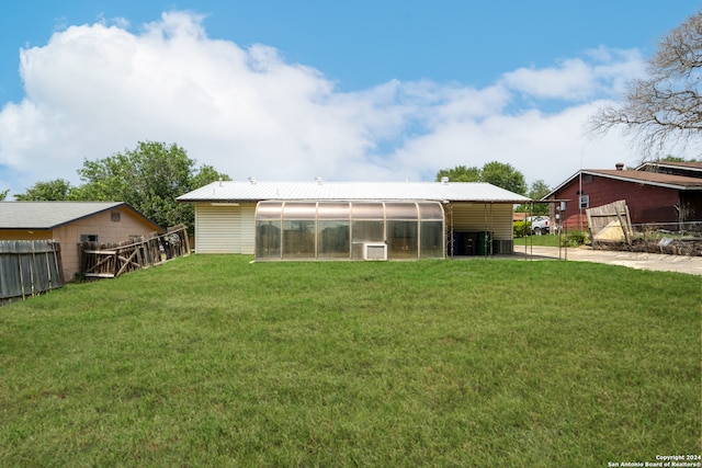 rear view of property with a lawn