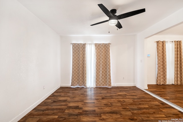 empty room featuring dark hardwood / wood-style flooring and ceiling fan