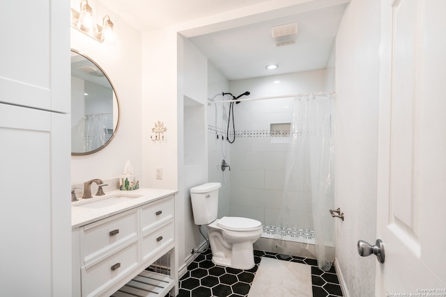 bathroom featuring toilet, vanity, tile patterned flooring, and curtained shower