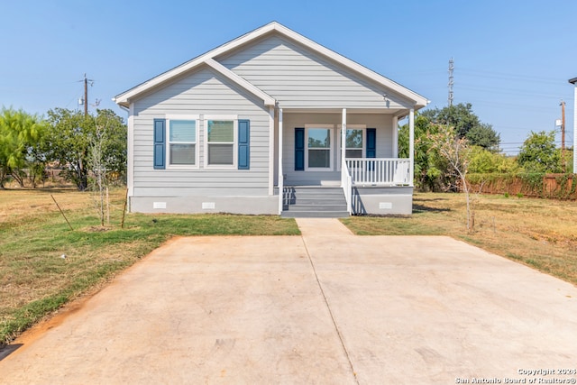 bungalow-style home featuring covered porch and a front lawn