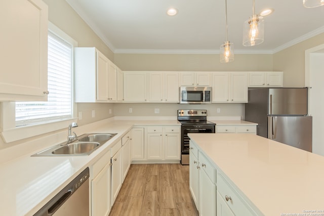 kitchen with stainless steel appliances, light hardwood / wood-style floors, white cabinetry, sink, and pendant lighting