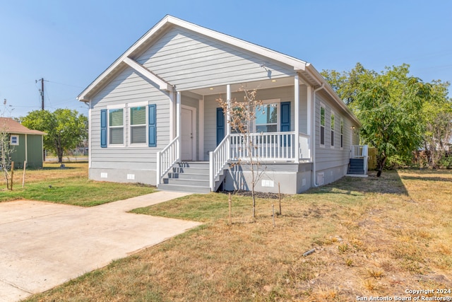 bungalow-style house with a front yard and covered porch