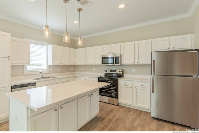 kitchen with hanging light fixtures, sink, a kitchen island, white cabinetry, and appliances with stainless steel finishes