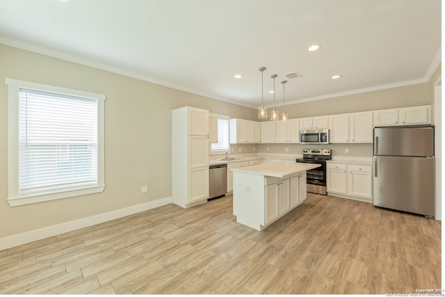 kitchen featuring plenty of natural light, light hardwood / wood-style flooring, hanging light fixtures, and stainless steel appliances