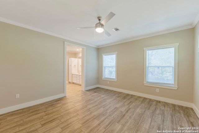 unfurnished room with a wealth of natural light, ornamental molding, and light hardwood / wood-style flooring