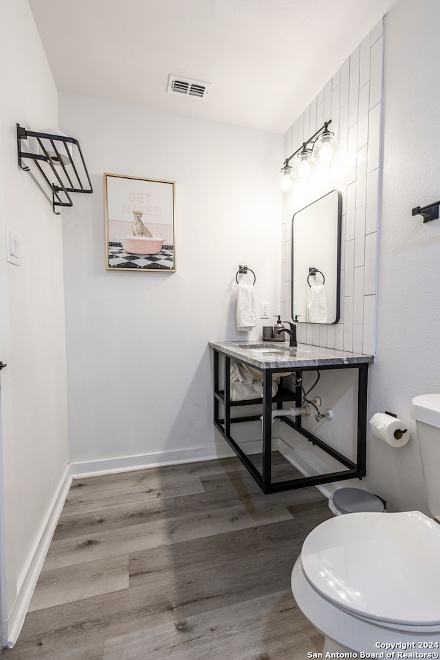 bathroom with hardwood / wood-style floors, toilet, and sink