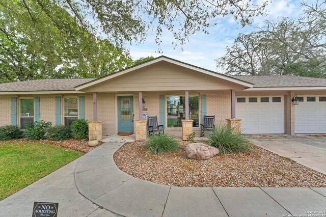 ranch-style home featuring a garage and a porch