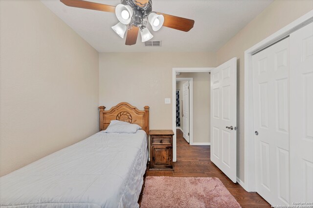 bedroom with dark hardwood / wood-style flooring, ceiling fan, and a closet