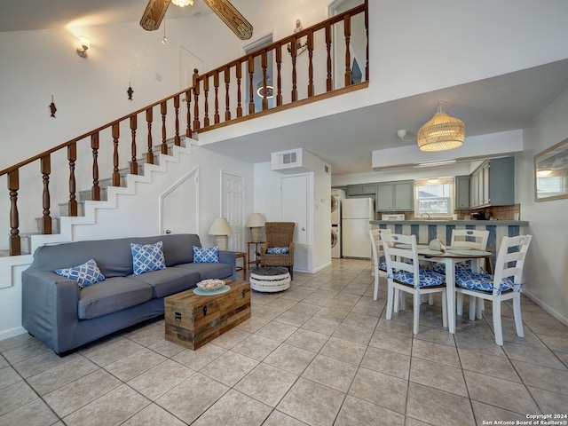 living room featuring high vaulted ceiling, light tile patterned flooring, ceiling fan, and sink