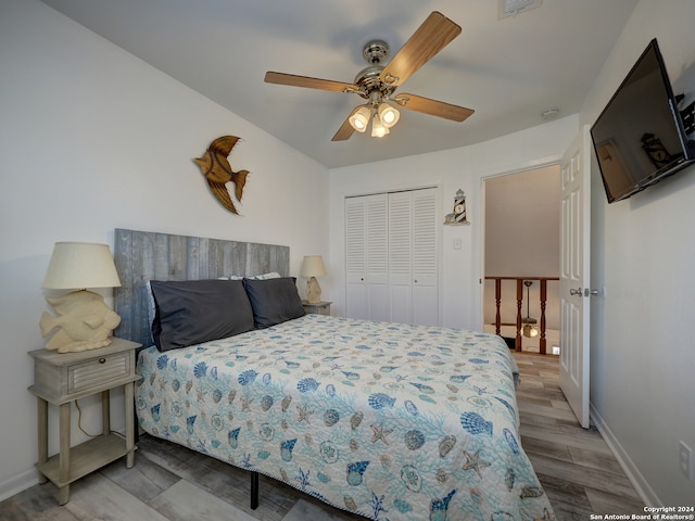 bedroom with light hardwood / wood-style floors, ceiling fan, and a closet