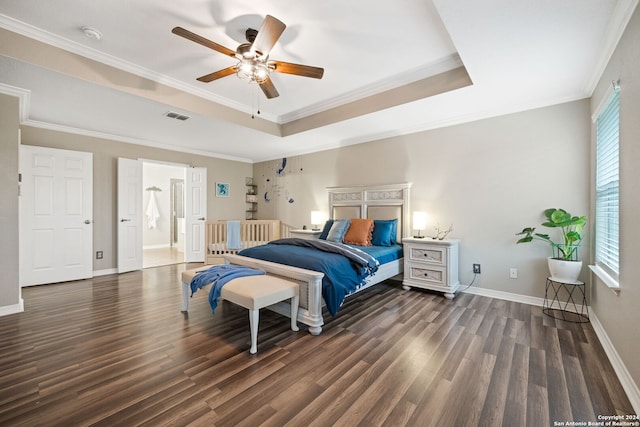 bedroom featuring crown molding, ceiling fan, dark hardwood / wood-style floors, and a tray ceiling