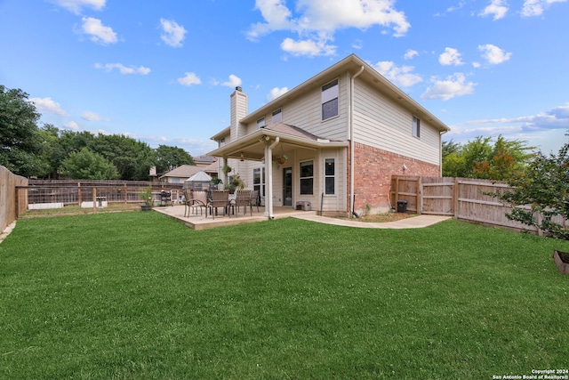 rear view of property with a lawn and a patio