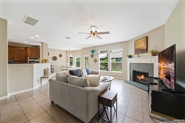 tiled living room with a fireplace and ceiling fan