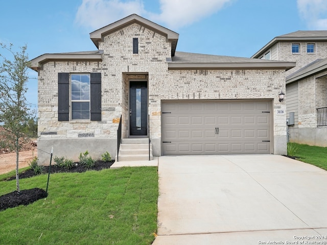 view of front of property featuring a garage and a front lawn