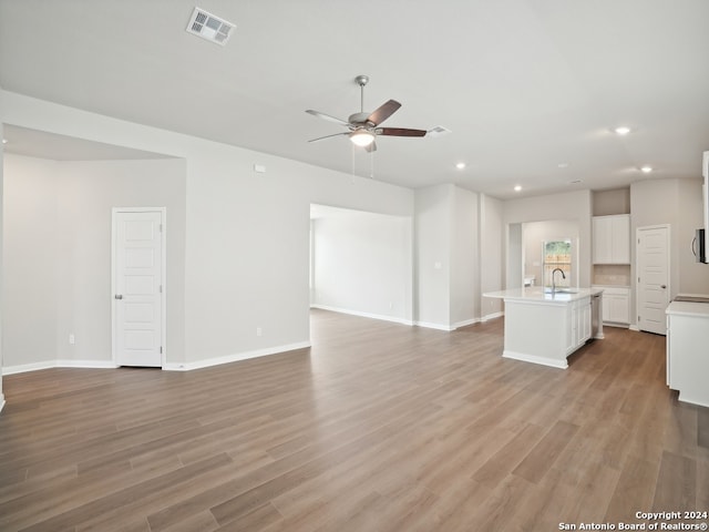 unfurnished living room with light wood-type flooring and ceiling fan