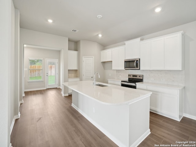 kitchen with sink, an island with sink, white cabinetry, light wood-type flooring, and appliances with stainless steel finishes