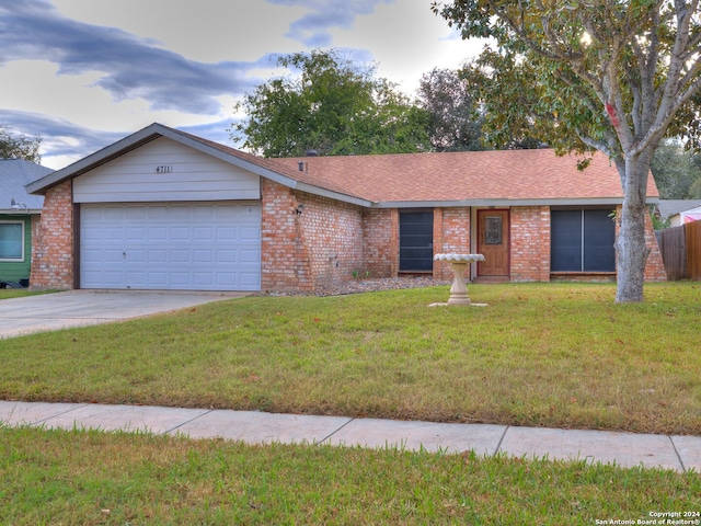 ranch-style house featuring a front yard and a garage