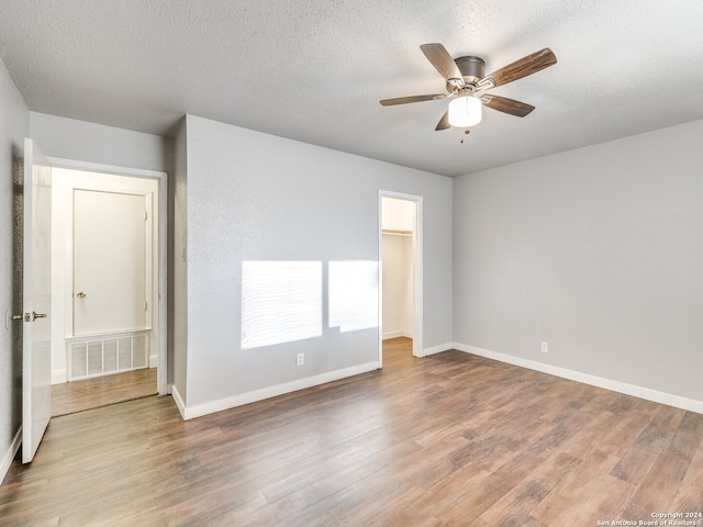 unfurnished room with hardwood / wood-style floors, a textured ceiling, and ceiling fan