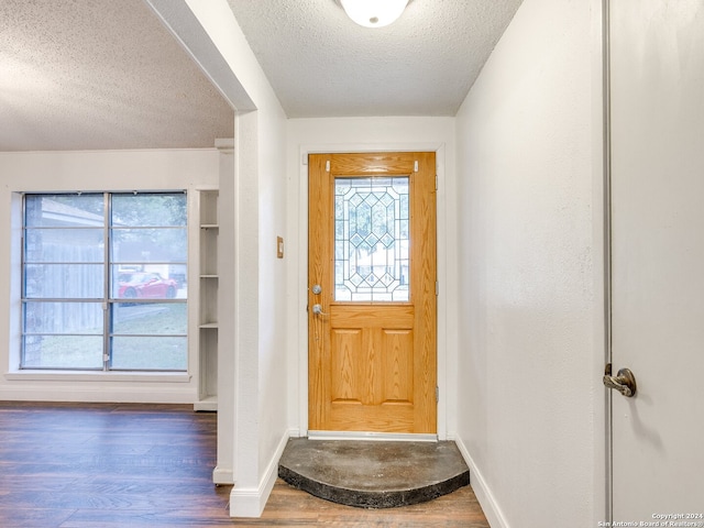 foyer featuring a textured ceiling and dark wood-type flooring