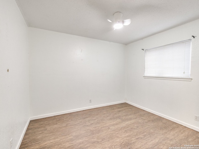 unfurnished room featuring hardwood / wood-style floors and a textured ceiling