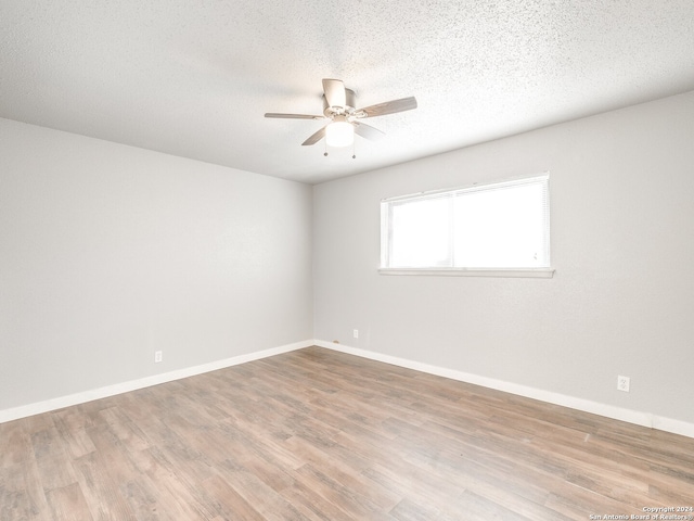 unfurnished room featuring ceiling fan, a textured ceiling, and light wood-type flooring