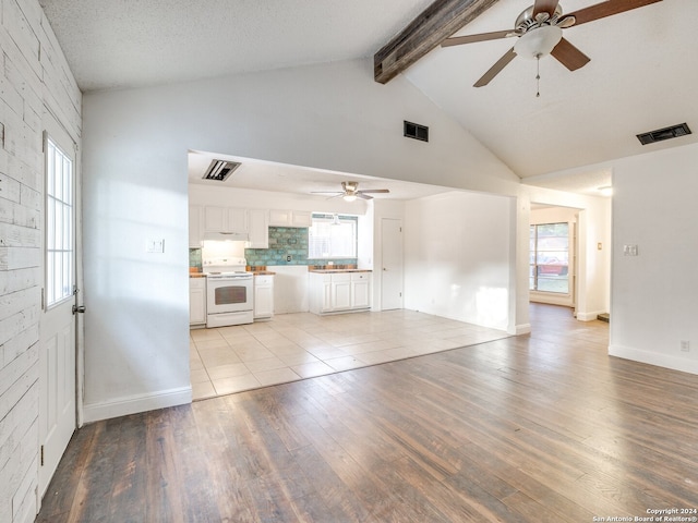 unfurnished living room with vaulted ceiling with beams, ceiling fan, light hardwood / wood-style floors, and a textured ceiling