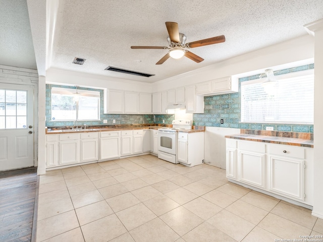 kitchen featuring white cabinets, white electric range, a textured ceiling, and backsplash