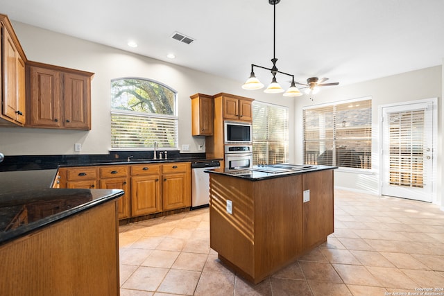 kitchen with light tile patterned flooring, appliances with stainless steel finishes, pendant lighting, sink, and a center island